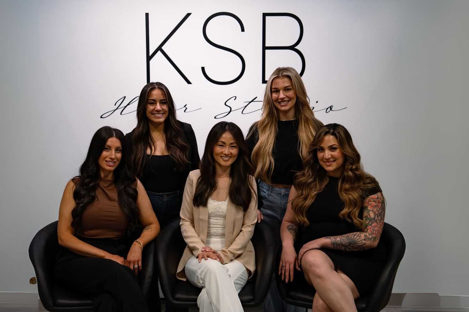 Group of five women posing at KSB Hair Studio, smiling in front of studio sign.